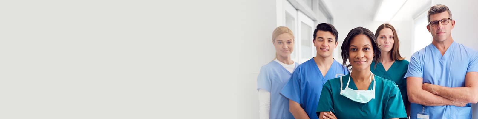 Nurses standing together in a row smiling.